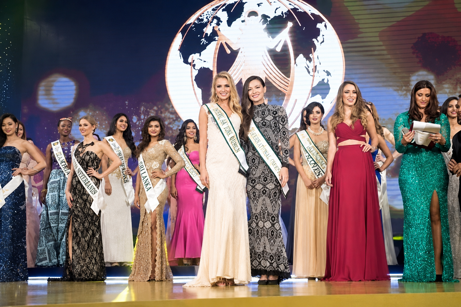 Pageant stage with globe backdrop and contestants in evening gowns